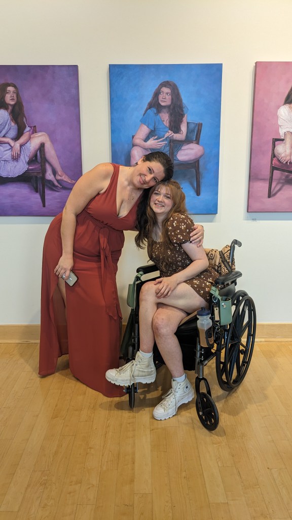 Brittany and I posing in front of the Woman in Chair series at our reception